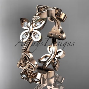Puede incluir: Un anillo de banda de oro rosa con un dise&ntilde;o de nudo celta y dos motivos de mariposa con peque&ntilde;os diamantes. El anillo es una pieza de joyer&iacute;a delicada e intrincada.