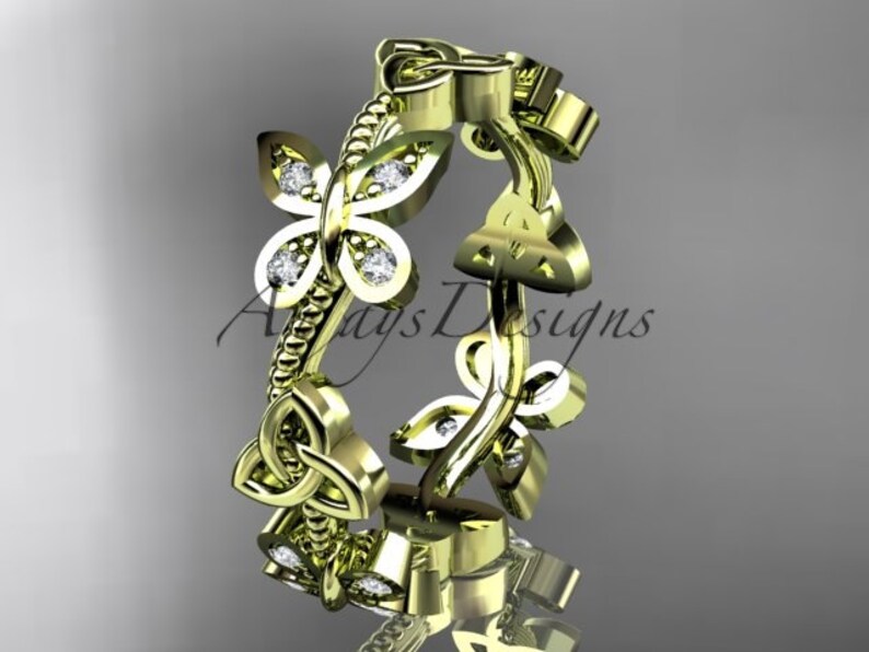 Puede incluir: Un anillo de oro con un dise&ntilde;o de nudo celta y un motivo de mariposa. El anillo est&aacute; engastado con peque&ntilde;os diamantes.