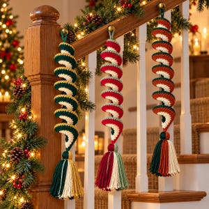 May include: Three hanging spiral ornaments crafted from crocheted yarn. Each piece features a distinct color scheme of red, green, and cream, ending in a thick, multi-colored tassel. The ornaments are suspended from loops at the top.