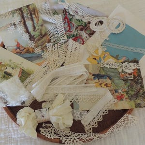 May include: A collection of white and cream lace trims, ribbons, and vintage-style postcards featuring illustrations of children and landscapes, all arranged together in a round, brown woven basket with a textured surface.