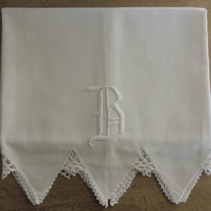May include: White embroidered linen pillowcase with a scalloped edge and a large embroidered letter "B" in the center.