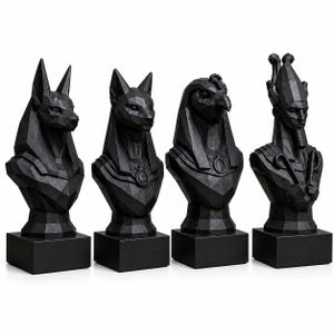 Puede incluir: Cuatro bustos geométricos negros de deidades egipcias, incluyendo Anubis, Bastet, Horus y un faraón. Cada busto está montado sobre una base rectangular negra. Las esculturas tienen un diseño angular moderno.