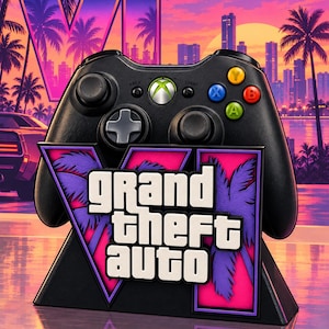 Puede incluir: Un mando de videojuegos negro sobre un soporte con el logotipo de Grand Theft Auto. El soporte muestra el texto Grand Theft Auto en letras blancas sobre un fondo rosa y morado con siluetas de palmeras y un gran número romano VI.