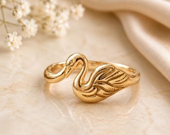 Elegante anillo envolvente con forma de cisne, acabado en oro, joyería inspirada en la naturaleza y los animales.