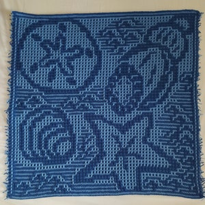 Może przedstawiać: Niebieski i jasnoniebieski kwadratowy koc wykonany na szydełku z kwiatowym wzorem.