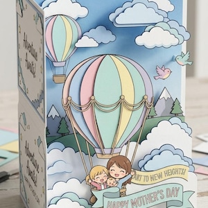 May include: A 3D Mother's Day card with a hot air balloon design. The card features a blue sky, clouds, and a pastel-coloured balloon. The banner reads "Happy Mother's Day". The words "Adventure Awaits!" are also visible.