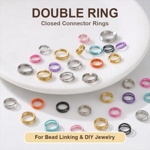 May include: A collection of multi-colored double rings for bead linking and jewelry making. The metal connector rings are available in silver, gold, black, pink, purple, orange, and teal tones, featuring a double-loop design for secure attachment.
