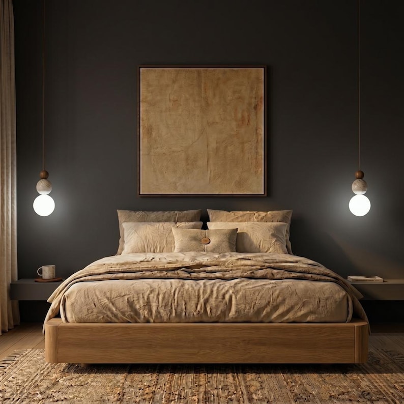 May include: A bedroom scene featuring a wooden bed frame with beige bedding and pillows. A large framed artwork hangs above the bed. Two pendant lights with spherical bulbs illuminate the space. The room has a dark gray wall and a patterned rug.