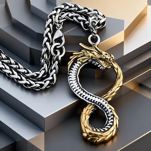 Könnte beinhalten: Eine silberfarbene Weizenkette mit einem Anhänger in Form eines Drachen, der ein Unendlichkeitssymbol bildet. Der Drachenanhänger ist zweifarbig gestaltet, mit einem goldfarbenen Kopf- und Schwanzbereich sowie einem silberfarbenen Körper.
