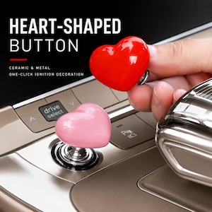 May include: A heart-shaped button for a car ignition, featuring a glossy red or pink ceramic top with a metal base. The text on the image reads: HEART-SHAPED BUTTON, CERAMIC & METAL, ONE-CLICK IGNITION DECORATION. The button is designed for vehicle use.