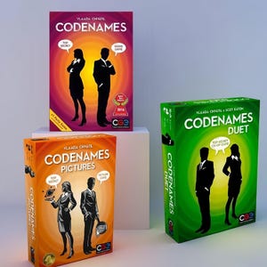Könnte beinhalten: Drei Codenames Brettspielschachteln: eine rote Codenames-Box, eine orangefarbene Codenames Pictures-Box und eine grüne Codenames Duet-Box. Jede Schachtel zeigt Silhouetten von zwei Figuren, Spieltitel und Sprechblasen mit Top Secret, Word Game oder Co-Op Game.