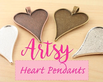 Puede incluir: Cuatro colgantes en forma de corazón en tonos plateado, bronce, cobre y latón. Cada colgante tiene un lazo para colgar. La imagen incluye el texto "Artsy Heart Pendants" en rosa.