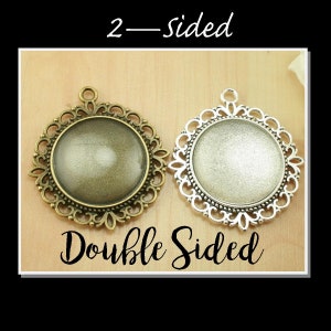 May include: Two-sided pendant with a filigree design. The pendant is made of metal and has a round, clear glass insert. The pendant is shown on a wooden surface. 2-Sided Double Sided