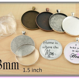 May include: A set of six silver-toned metal pendant trays, each measuring 1.5 inches in diameter. The trays have a textured surface and are designed to hold a variety of materials, such as resin, glass, or paper. The trays are shown with a clear glass dome, a silver-toned metal tray, and two finished pendants with the text "Home is where the Mom is..." and "I hold you in my Heart".