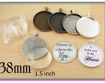 Op de afbeelding: Een set van zes zilverkleurige metalen hanger-schalen, elk met een diameter van 3,8 cm. De schalen hebben een getextureerd oppervlak en zijn ontworpen om een ​​verscheidenheid aan materialen te bevatten, zoals hars, glas of papier. De schalen worden getoond met een transparante glazen koepel, een zilverkleurige metalen schaal en twee afgewerkte hangers met de tekst "Home is where the Mom is..." en "I hold you in my Heart".