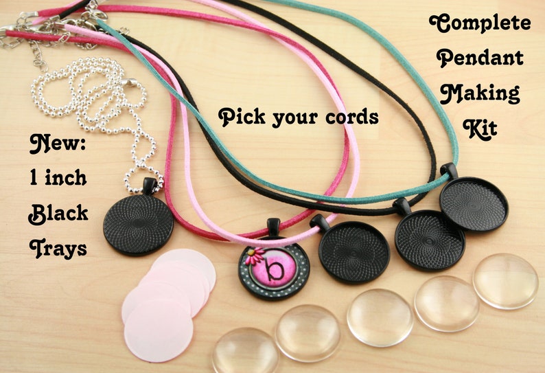 May include: Complete Pendant Making Kit with 1 inch black trays, pink cords, teal cords, black cords, and a silver chain.  The kit includes four round glass cabochons, four round black metal pendant bases, and one round pendant base with a pink and white flower design and the letter "b".  Pick your cords text is visible in the image.