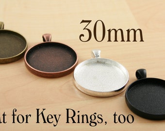 May include: Four 30mm round metal pendant trays in different finishes: antique brass, copper, silver, and black.  The trays are great for key rings, too.