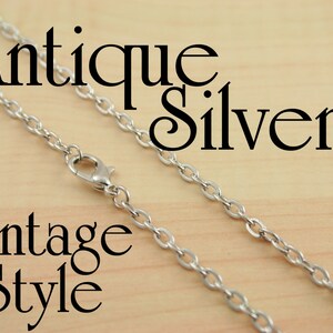 May include: Antique silver chain necklace in a vintage style. The chain is made of small, oval-shaped links.