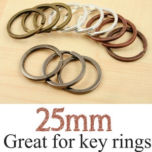 May include: Assortment of 25mm key rings in various metallic finishes, including bronze, silver, and copper. The key rings are displayed on a light wood surface. Text on the image reads "25mm Great for key rings."