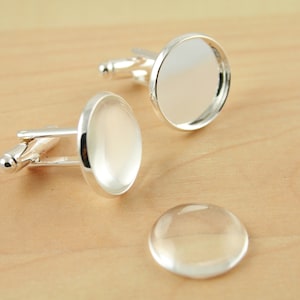 May include: Two silver cufflinks with clear glass cabochons and a separate clear glass cabochon.