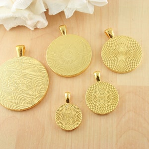 May include: Five gold-colored metal pendant trays of different sizes. The trays are round and have a textured surface. They are all facing the camera.