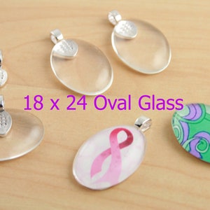 May include: Five oval glass pendants with silver bail caps. The glass pendants are clear, except for one with a pink ribbon design and another with a green and purple swirl design. The text "18 x 24 Oval Glass" is printed below the pendants.