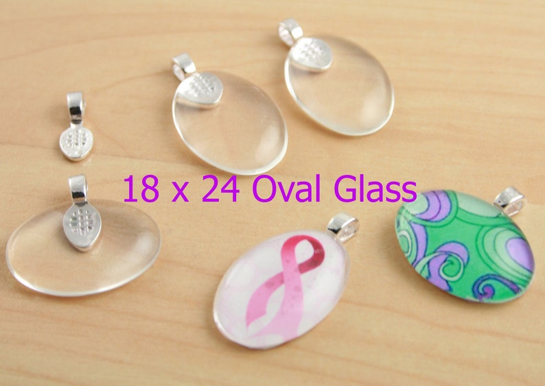 May include: Five oval glass pendants with silver bail caps. The glass pendants are clear, except for one with a pink ribbon design and another with a green and purple swirl design. The text "18 x 24 Oval Glass" is printed below the pendants.