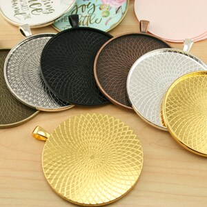 May include: Assortment of six round metal pendant trays with a decorative swirl pattern. The trays are in various finishes, including gold, silver, bronze, and black.