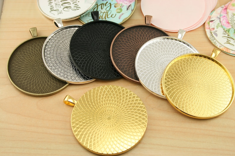 May include: Assortment of six round metal pendant trays with a decorative swirl pattern. The trays are in various finishes, including gold, silver, bronze, and black.