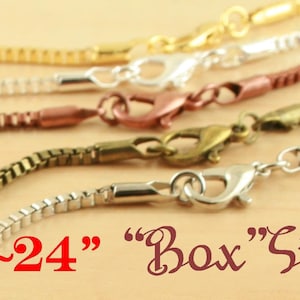 Könnte beinhalten: Fünf verschiedene Kettenarten in Gold, Silber und Bronze mit Karabinerverschlüssen. Die Ketten sind etwa 61 cm lang und mit "Box"-Stil gekennzeichnet.