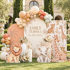 Könnte beinhalten: Ein Party-Hintergrundset mit einem Bogenschild mit der Aufschrift Emily Turns 1 Our Little Wild One, umgeben von einer Ballongirlande in Beige, Pfirsich und Salbei. Enthält Aufsteller von Löwe, Elefant und Giraffe auf einem Rasen.