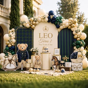 Op de afbeelding: Een verjaardagsdecoratie met een grote boog met de tekst LEO Turns 2 Two Years of Joy, omringd door een ballonslinger in crème, goud, marineblauw en donkergroen. Inclusief teddybeer-uitsparingen, een hobbelpaard en een kinderwagen.