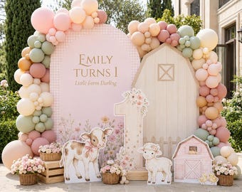 May include: A party backdrop featuring a pink arched sign with the text Emily Turns 1 Little Farm Darling, a wooden barn cutout, and a large number one. The display is decorated with a balloon garland in shades of pink, peach, and sage green, alongside cutouts of a calf, a lamb, and a small barn, with baskets of flowers.