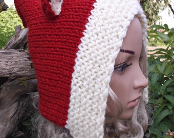 May include: A handmade red, white, and black fox hat. The hat is knit with a red crown and white trim, featuring fox ears and a black tail. The hat is designed to be worn on the head.