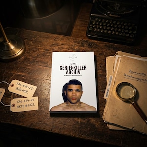 Può includere: Un libro intitolato Das Serienkiller Archiv di Stephen Akinmurele con il ritratto di una persona sulla copertina. Il libro è posizionato su una superficie in legno scuro accanto a due etichette di carta con scritto Tag #14-23: Bücher e Tag #14-24: Akte #002, una lente d'ingrandimento e documenti.