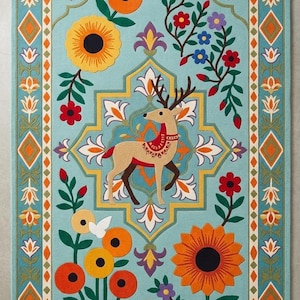 May include: A rectangular area rug with a light blue background featuring a central tan deer with antlers, surrounded by colorful floral motifs, orange sunflowers, and small birds. The border displays a geometric pattern of diamonds and leaves.