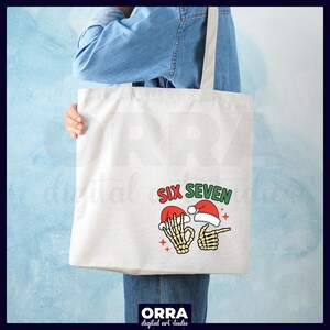 May include: A white tote bag with a graphic that says "SIX SEVEN" in red and green. The graphic features two skeleton hands wearing Santa hats, one making an "okay" sign and the other pointing.