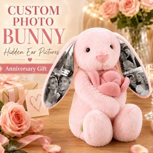 May include: A plush pink bunny toy holding a pink fabric rose. The bunny features long ears with black and white printed photographs of a couple on the inner surfaces. Text on the image reads: CUSTOM PHOTO BUNNY Hidden Ear Pictures Anniversary Gift.