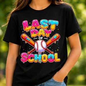 May include: Black t-shirt with a colourful graphic design. The design features the text "LAST DAY OF SCHOOL" in a playful, donut-style font, along with crossed baseball bats and a baseball. The design includes pink, blue, yellow, and orange colours.