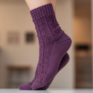 May include: A pair of purple knitted socks with a textured pattern. The socks have a solid colour with a ribbed cuff and a detailed design on the front. The socks are worn on a person's feet.