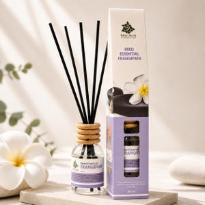以下が含まれることがあります： 「Reed Essential Frangipani」とラベルされた、黒いリードと木製のカラーが付いた透明なガラス瓶。お揃いの箱には、製品名とフランジパニの花が表示されています。この製品は、30mlのエッセンシャルオイルディフューザーです。