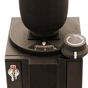 May include: A black coffee grinder with a ribbed top, a dial marked from 0 to 10, and a knob labelled "FINE" and "COARSE". The grinder has an on/off switch.