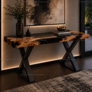 Puede incluir: Una consola moderna con base de metal negro y tapa rectangular. La tapa de la mesa presenta un diseño único con resina epoxi negra y un patrón marrón similar a la madera. Un jarrón con vegetación y libros están sobre la mesa.