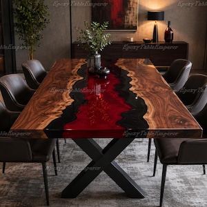May include: A striking dining table with a wooden top and a central river of red and black resin. The table, approximately 240 cm long, is supported by a black metal base. Six brown leather chairs surround the table, creating a modern dining set.