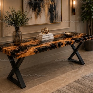May include: A rectangular console table featuring a live-edge wood slab with black resin fill, supported by a black metal X-shaped base. The surface is polished and glossy, displaying natural wood grain patterns alongside dark, opaque resin sections.