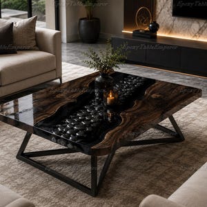 May include: A rectangular coffee table featuring a live-edge dark wood slab with a central river design filled with black river stones encased in clear epoxy resin. The table is supported by a black metal geometric frame base.