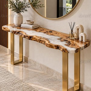 May include: A console table featuring a live-edge wood slab with a white epoxy resin center inlay, supported by two brushed gold metal U-shaped legs. The tabletop surface holds a textured white vase with greenery, two stacked books, and decor.