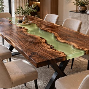 May include: A rectangular dining table featuring a live edge dark walnut wood slab with a central translucent pale green epoxy resin river inlay. The table is supported by a black metal X-shaped base and is surrounded by six beige upholstered chairs.