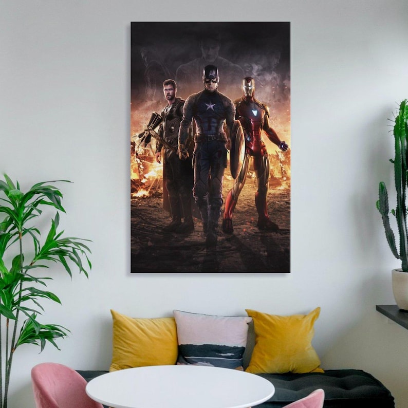May include: A framed canvas print featuring three superheroes: Captain America, Iron Man, and Thor, set against a fiery background. Captain America holds a shield, Iron Man is in a red and gold suit, and Thor carries a weapon. The artwork has a dark, dramatic tone.