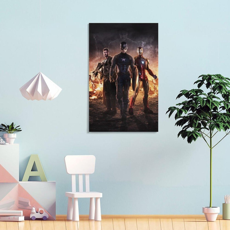 May include: A framed canvas print featuring three superheroes: Captain America, Thor, and Iron Man. The heroes are walking towards the viewer against a fiery background. Captain America holds his shield.